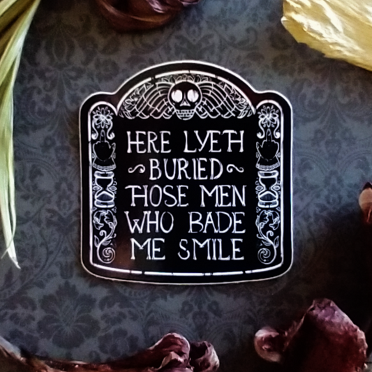A black and white sticker of an illustration of a headstone, which reads, "Here lyeth buried those men who bade me smile".